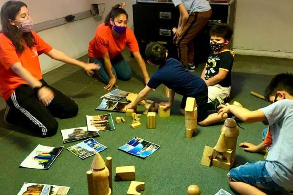 Niñas y niños jugando en el tríptico junto a auxiliares