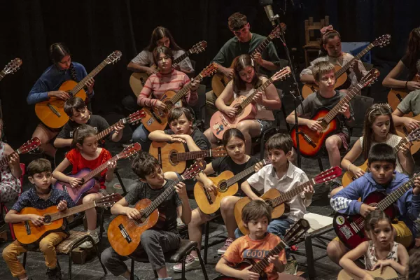 niños tocan la guitarra en el escenario