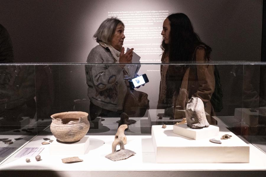 Piezas prehispánicas de la muestra del Museo de la Ciudad Yo soy de donde hay un río. Dos señoras conversan detrás.