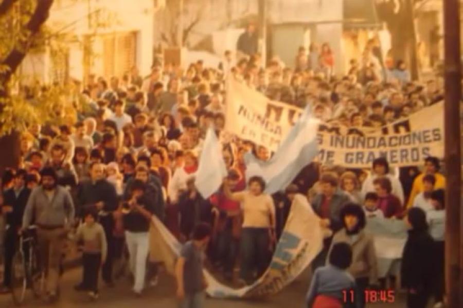 Imagen después de la Gran inundación de 1986 donde se ve a un grupo de personas movilizándose bajo la consigna  Nu.Ma.In (Nunca Más Inundaciones)