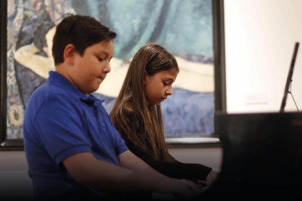 Niños tocan el piano en la Escuela de Música